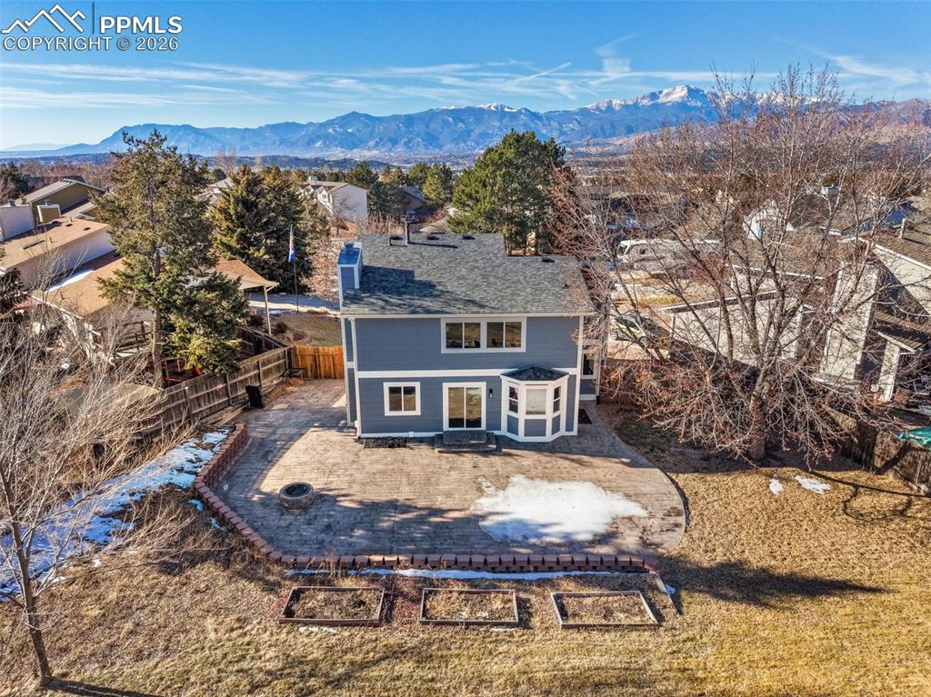 Image 18 of 36: Rear view of property featuring a mountain view, a fenced backyard, and a p