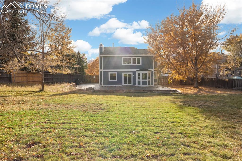 Image 33 of 36: Fenced backyard featuring a playground, a storage shed, and a built fire pi