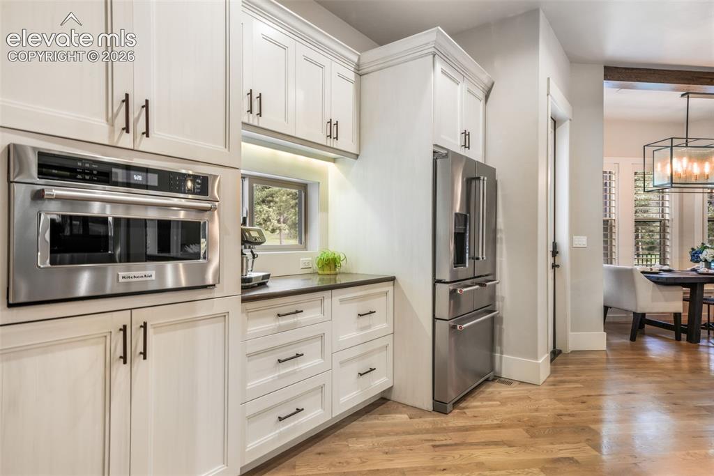 Image 21 of 50: Open-concept kitchen and dining area featuring light wood-finish flooring, 