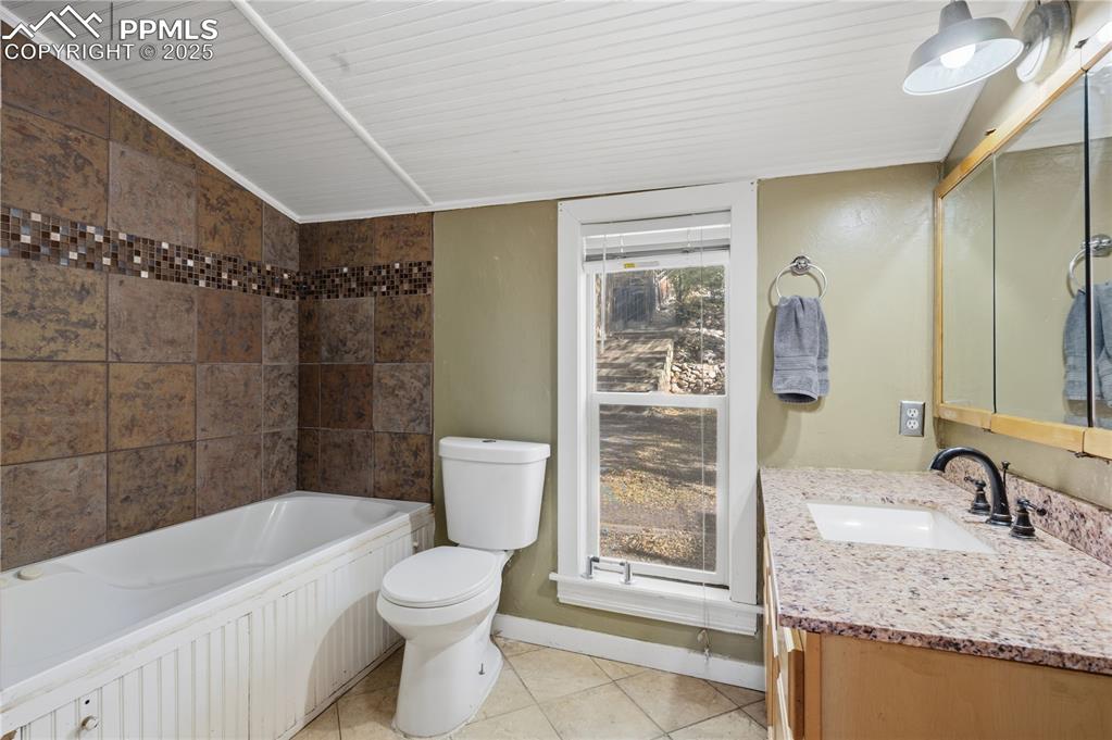 Image 16 of 36: Full bathroom with vanity, light tile patterned floors, and shower / bathtu