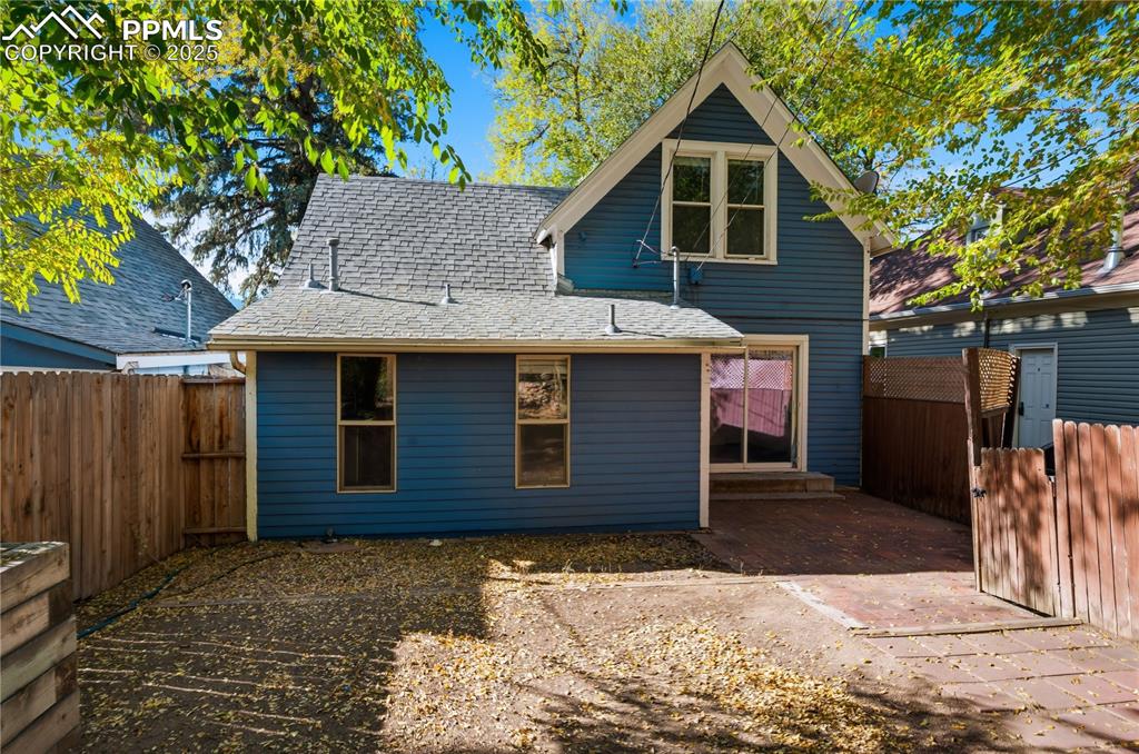 Image 30 of 36: Back of house with roof with shingles and a fenced backyard