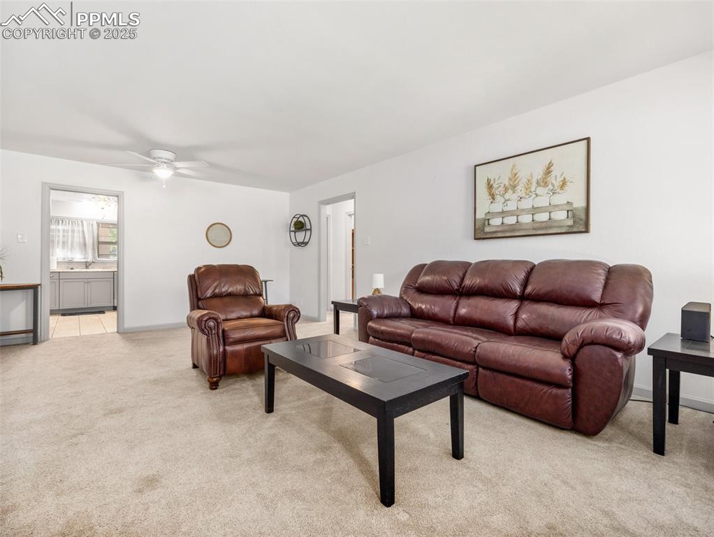 Image 11 of 18: Living room featuring light carpet and a ceiling fan