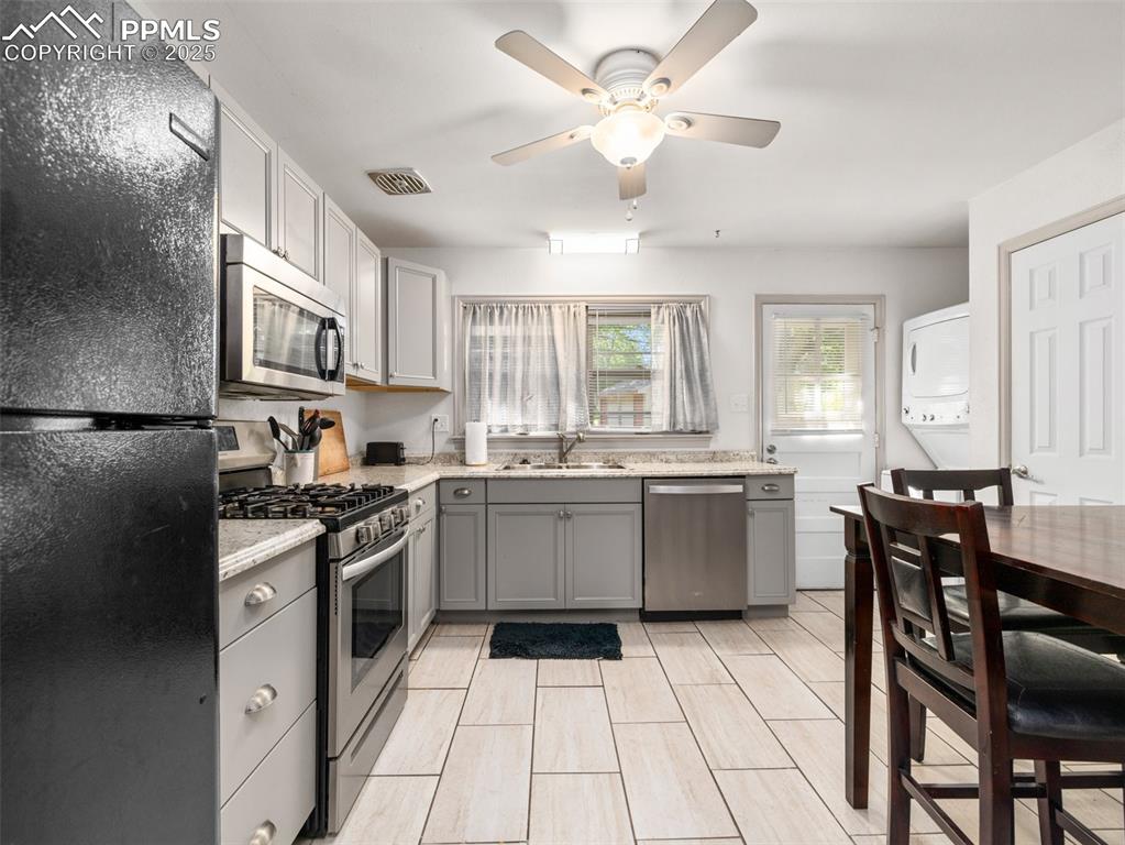 Image 13 of 18: Kitchen featuring appliances with stainless steel finishes, gray cabinetry,