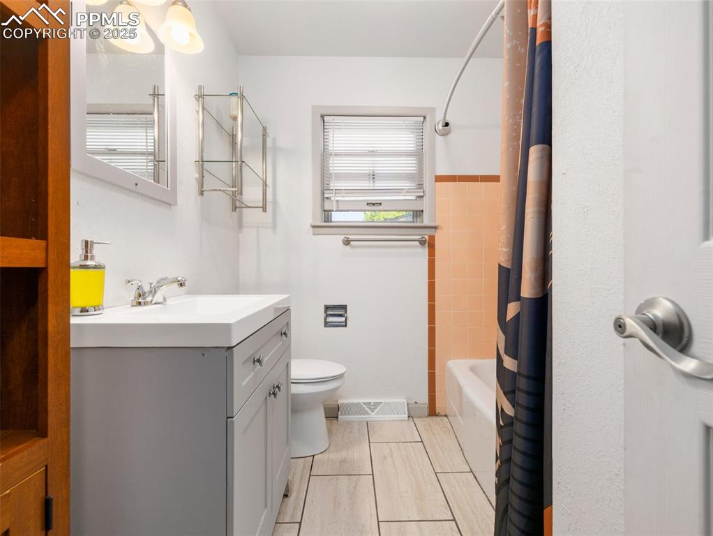 Image 6 of 18: Bathroom with plenty of natural light, vanity, and shower / tub combo