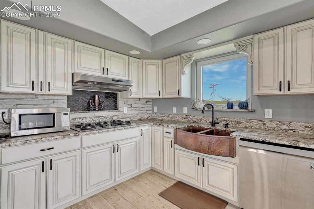 Image 20 of 50: Kitchen with appliances with stainless steel finishes, light granite counte