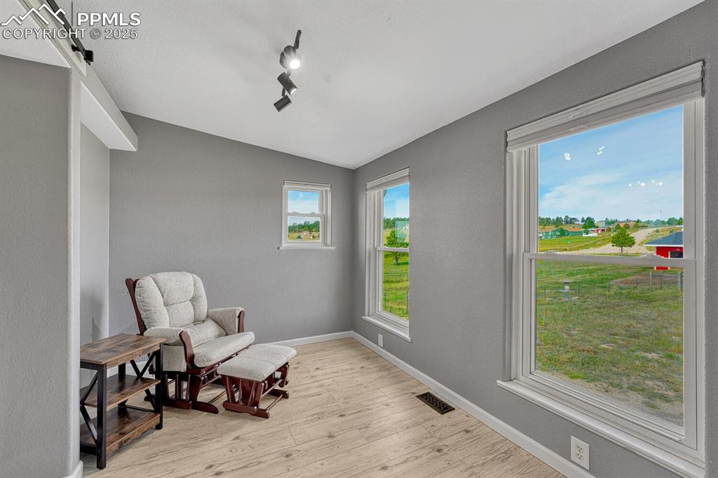 Image 29 of 50: Sitting room between primary bedroom and primary bathroom with tons of ligh