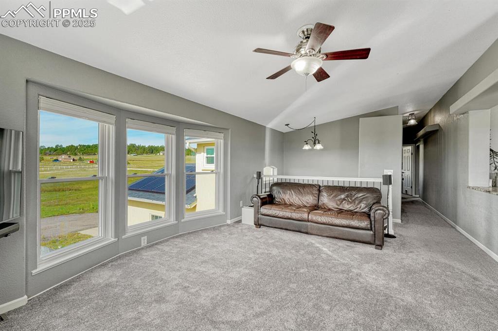 Image 35 of 50: Living room with vaulted ceiling, carpet floors, a chandelier, and ceiling