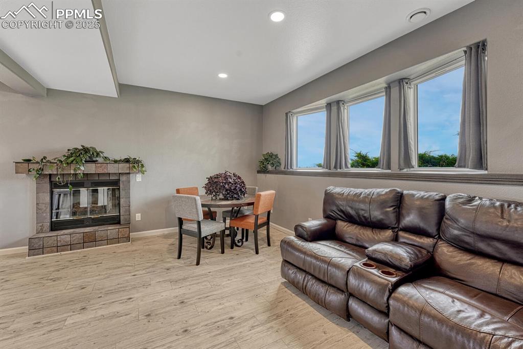 Image 37 of 50: Family room featuring light wood-style flooring, a tiled fireplace, and rec