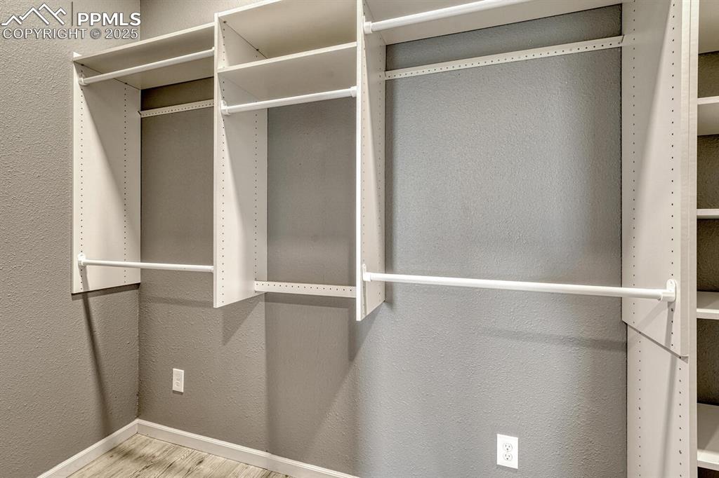 Image 47 of 50: Spacious closet with wood finished floors