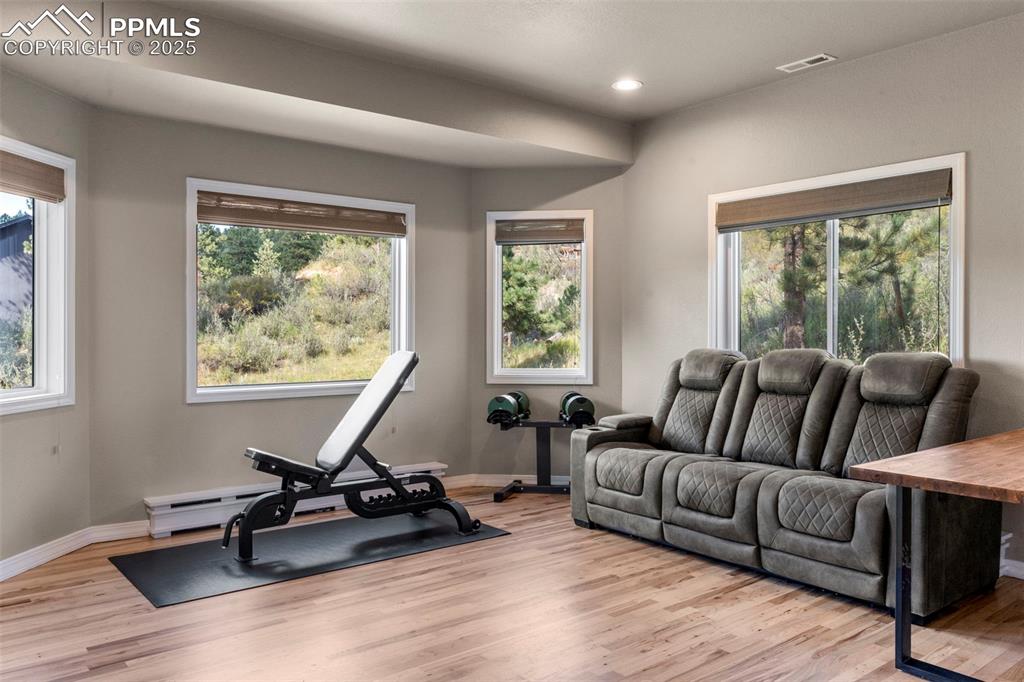 Image 14 of 46: Workout room featuring light wood-type flooring, recessed lighting, and bas