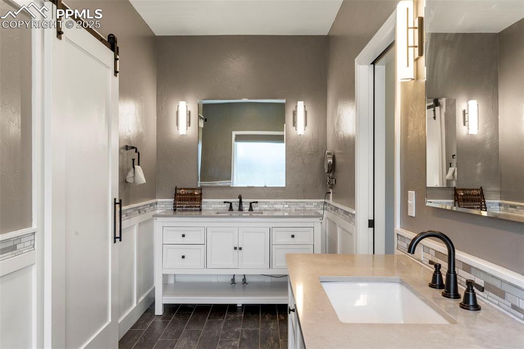 Image 18 of 46: Bathroom featuring vanity, wood tiled floors, and backsplash