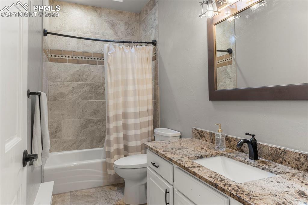 Image 24 of 46: Full bath with shower / tub combo with curtain and vanity