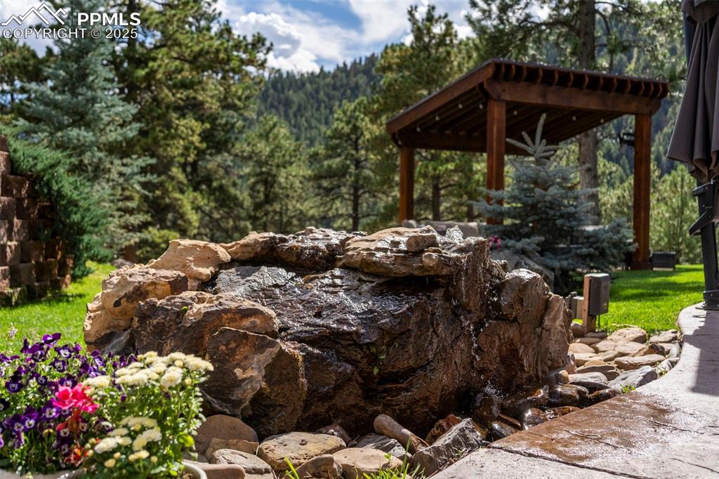 Image 34 of 46: View of yard featuring a garden pond and a view of trees