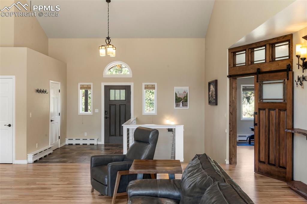 Image 6 of 46: Foyer entrance featuring high vaulted ceiling, light wood-style floors, a b
