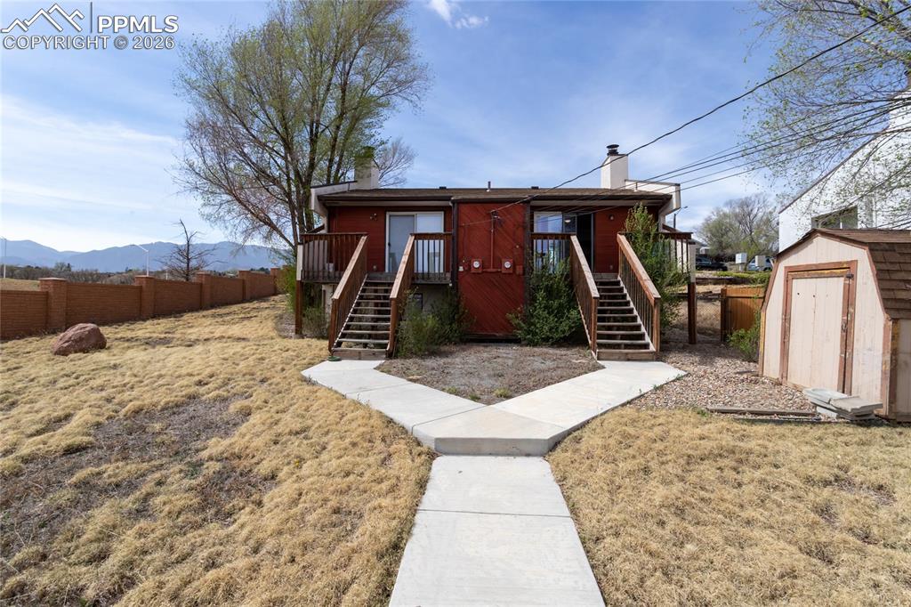 Image 34 of 39: Back of duplex faces east. Storage shed is included.