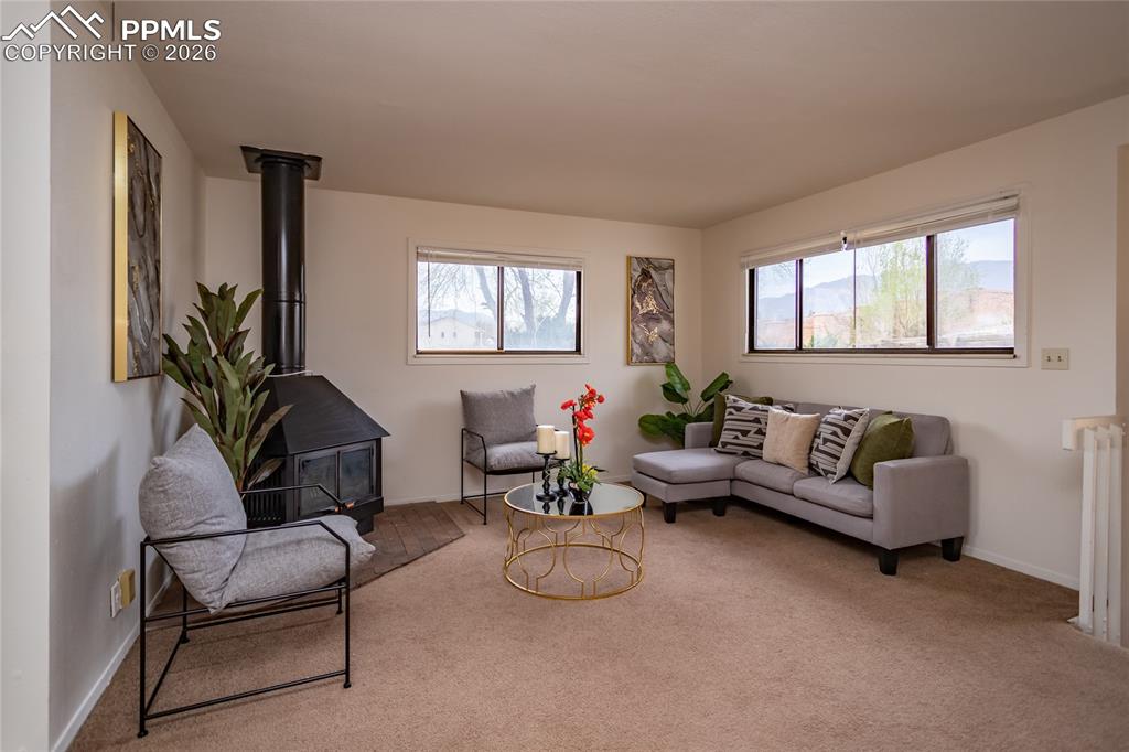 Image 4 of 39: Living room with wood burning stove and mountain views. Unoccupied unit 190