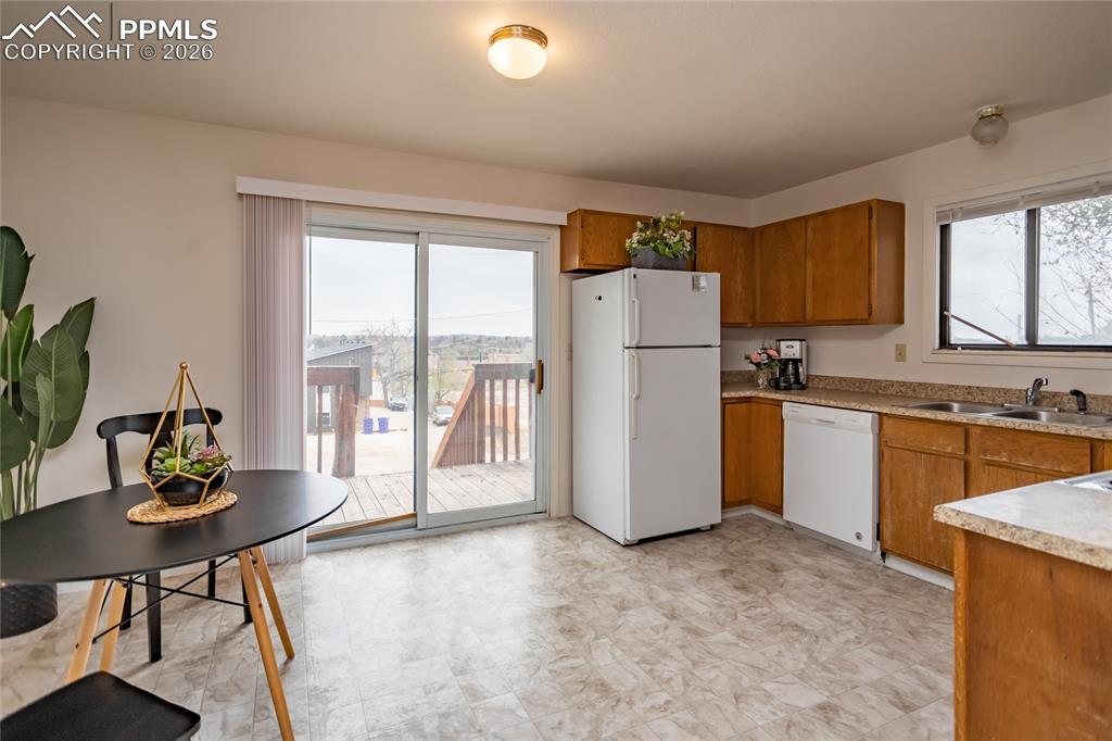 Image 7 of 39: Dining and kitchen and deck is on the east side of the duplex. Unoccupied u