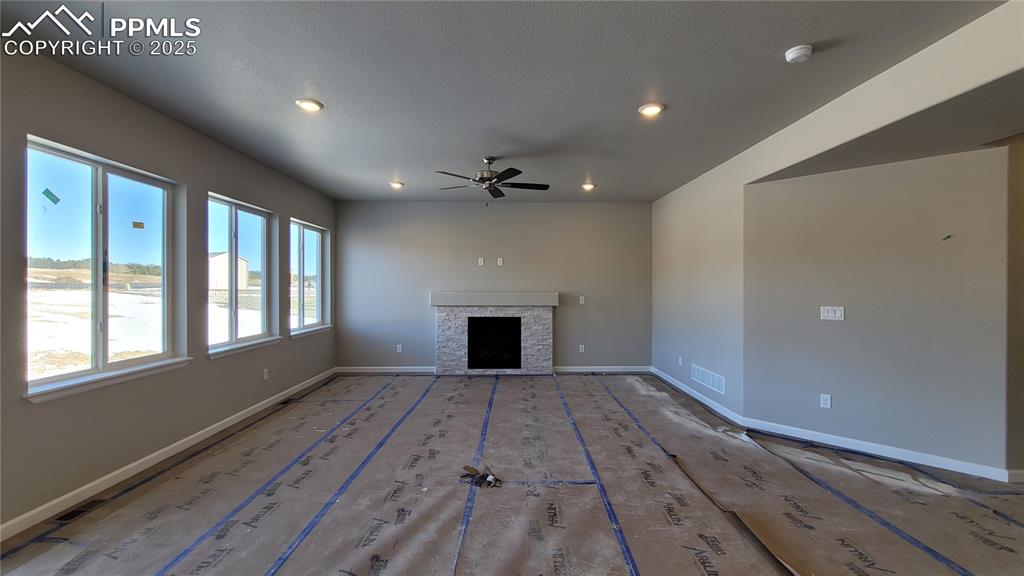Image 4 of 35: Great room with engineered wood flooring, floor outlet, ceiling fan, LED li