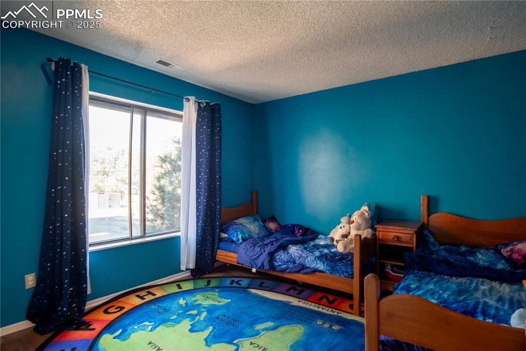 Image 16 of 29: Bedroom with large windows and mountain views 