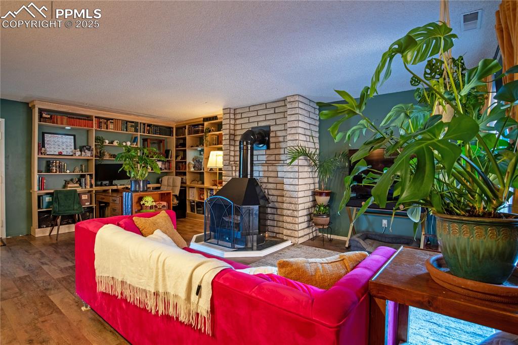 Image 7 of 29: Living room featuring a wood-burning fireplace 