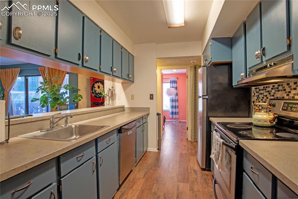 Image 9 of 29: Kitchen with stainless steel appliances, light countertops, under cabinet r