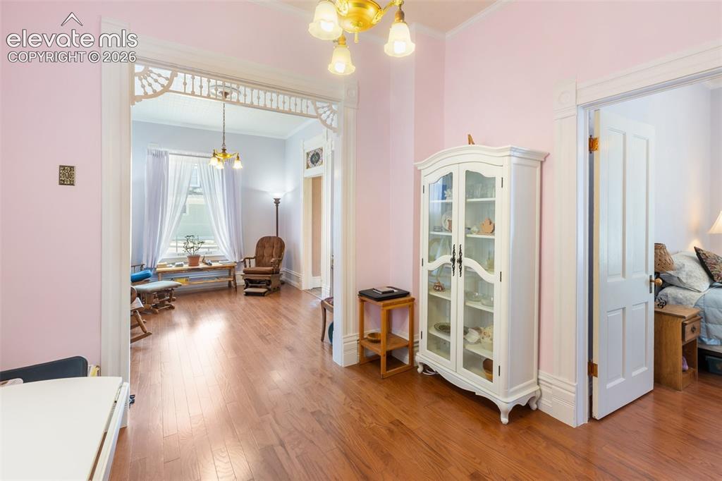 Image 11 of 29: Decorative Victorian fretwork above the wide room openings.