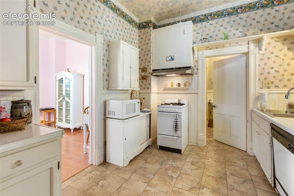Image 16 of 29: White cabinetry and white appliances complement this open kitchen setting. 