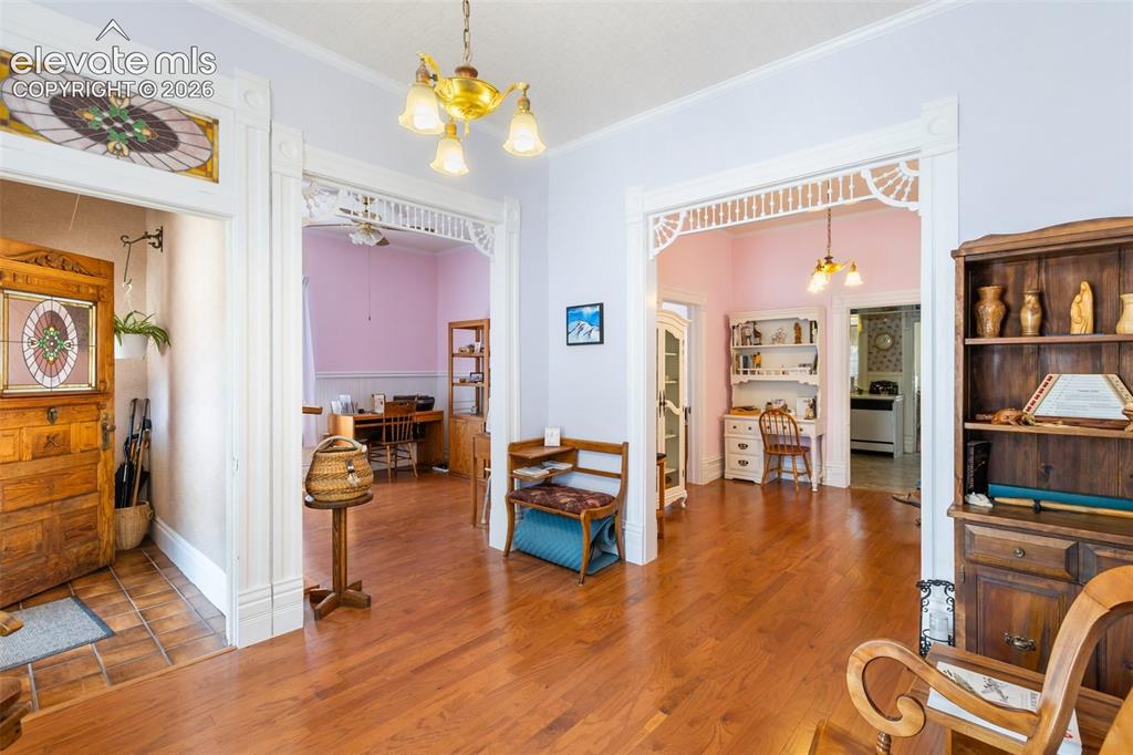 Image 5 of 29: Living room with stained glass and period lighting fixtures.