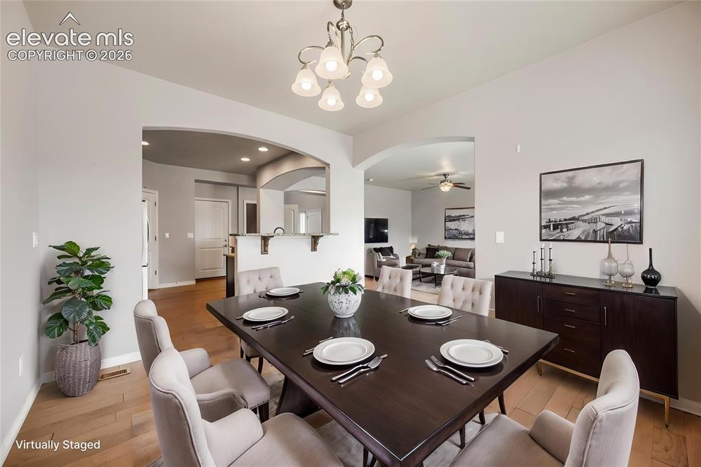 Image 11 of 41: Wood-finish flooring, recessed lighting, and arched doorways provide a refi