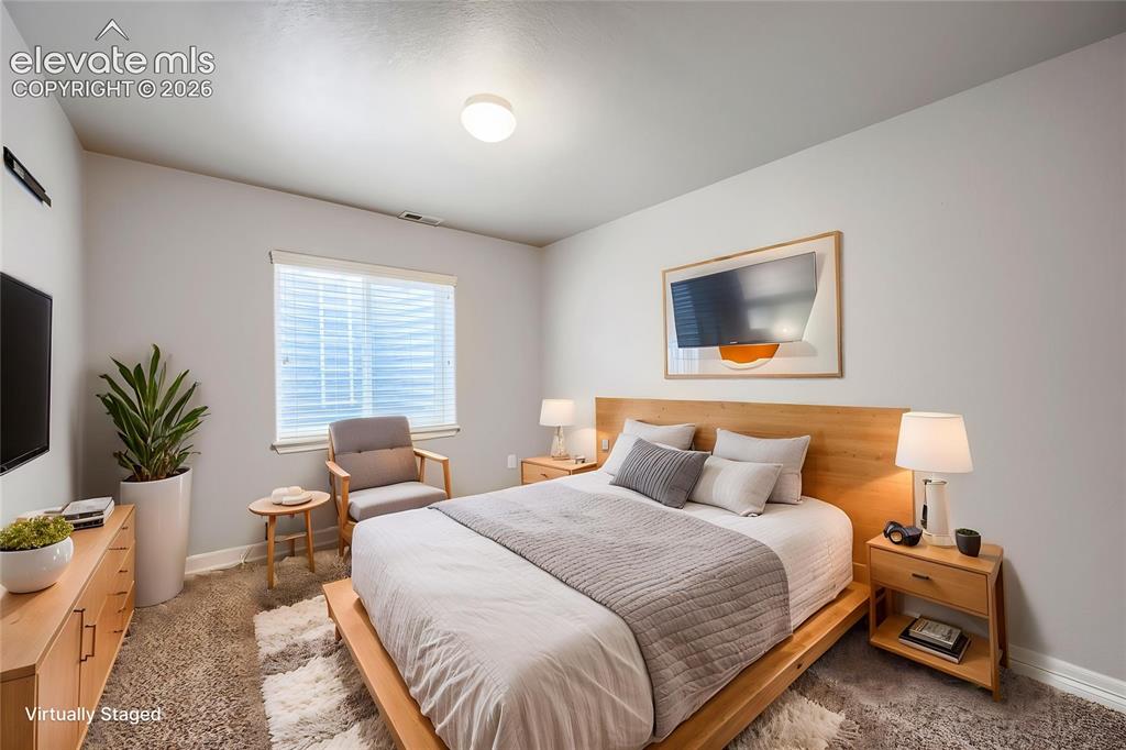 Image 26 of 41: Spacious room with light-toned walls, a window with horizontal blinds, and 