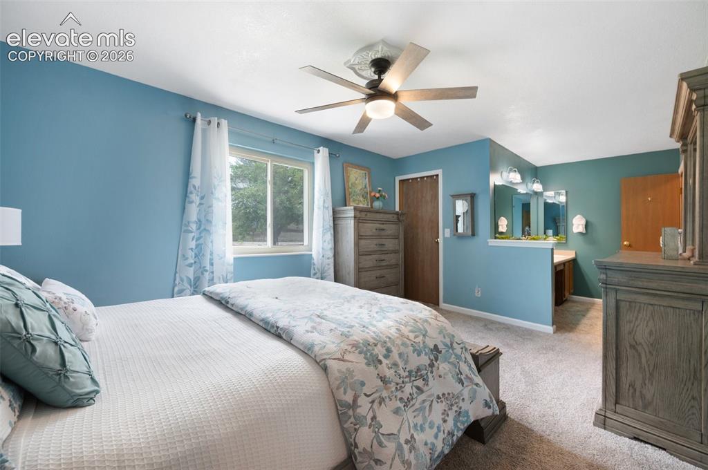 Image 16 of 50: Bedroom with light carpet, baseboards, a closet, and a ceiling fan