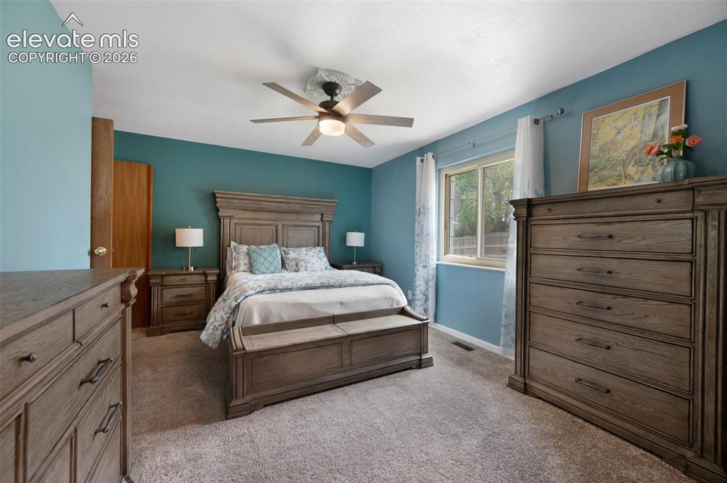 Image 18 of 50: Bedroom featuring light carpet, ceiling fan, and baseboards