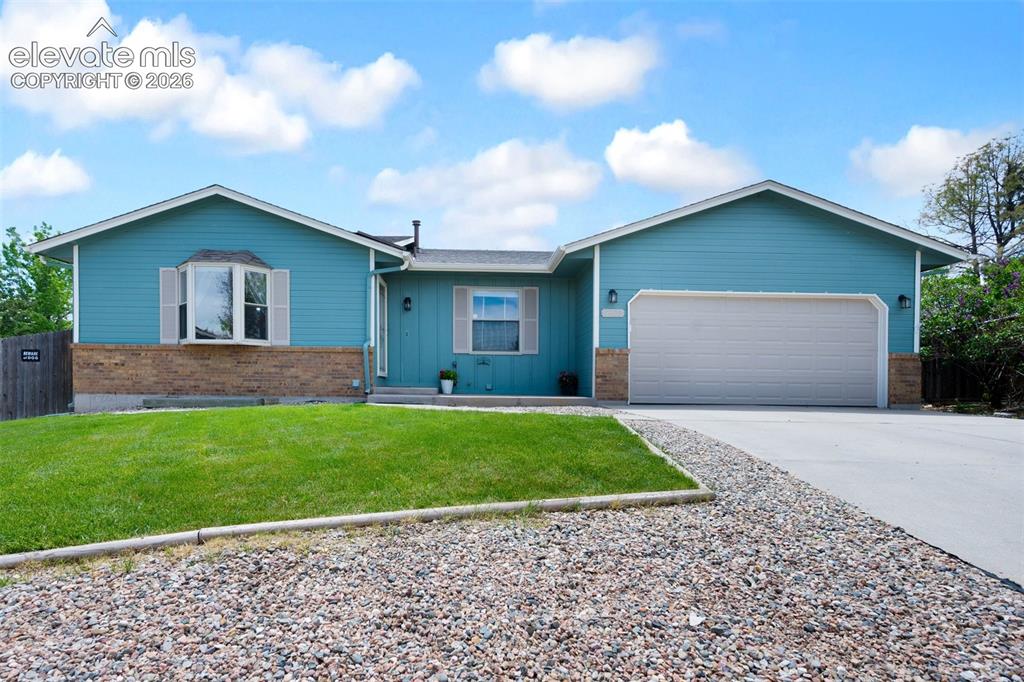 Image 2 of 50: Ranch-style house featuring an attached garage, driveway, brick siding, and