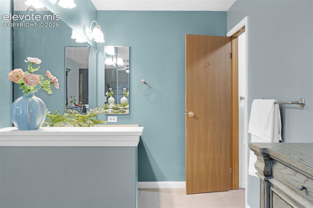 Image 20 of 50: Bathroom vanity area featuring a white-trimmed counter, dual rectangular mi