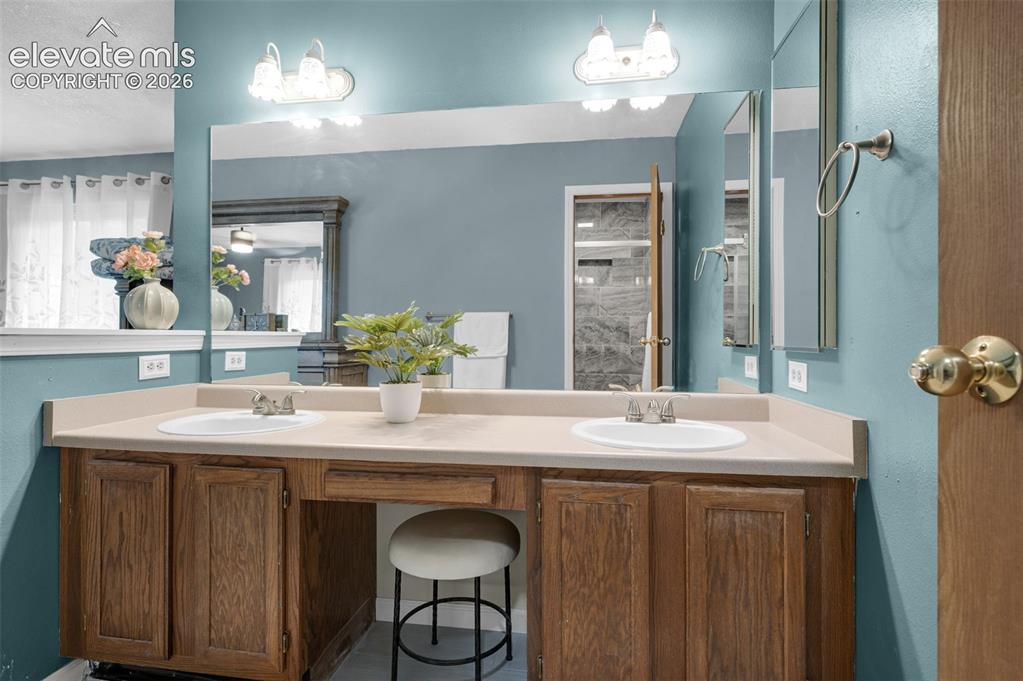 Image 21 of 50: Double vanity with integrated sinks, a spacious countertop, wood cabinetry,