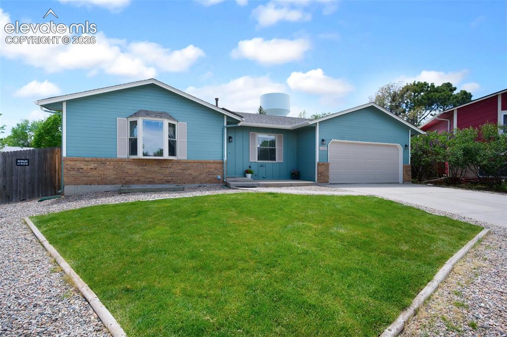Image 3 of 50: Single story home with brick siding, a garage, and concrete driveway