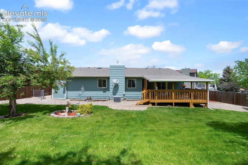Image 45 of 50: Rear view of property featuring a wooden deck and a chimney