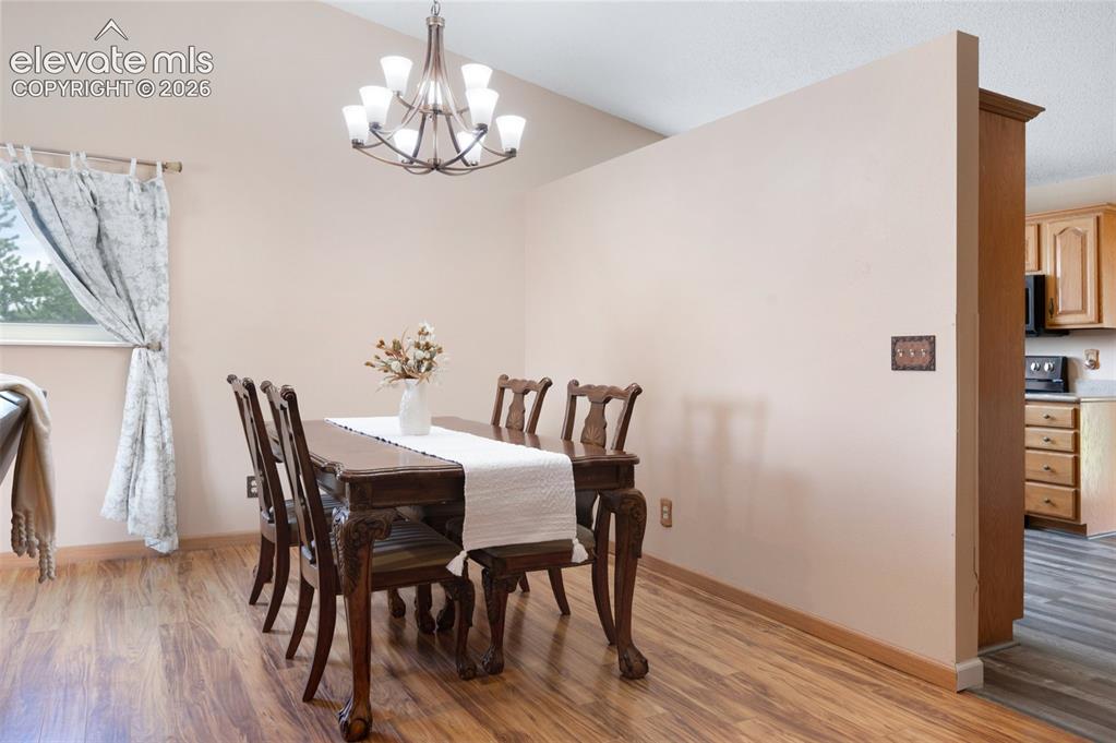 Image 8 of 50: Dining room featuring a chandelier, light wood-type flooring, and baseboard