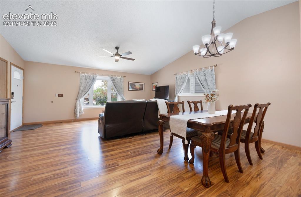 Image 9 of 50: Dining room featuring lofted ceiling, light wood-style floors, a ceiling fa