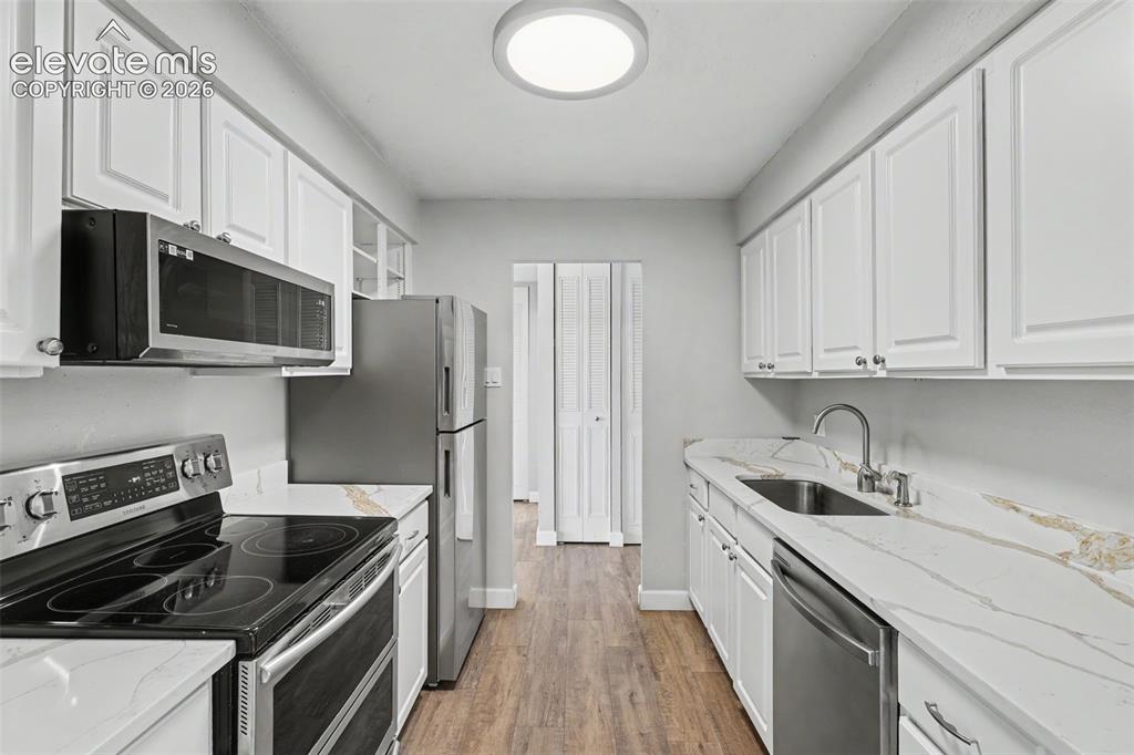 Image 13 of 25: The Kitchen features gorgeous countertops and comes equipped with a Refrige