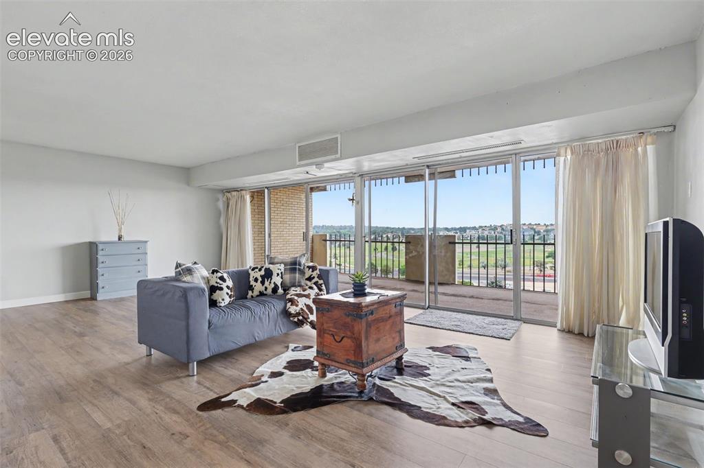 Image 3 of 25: The spacious Living Room has large windows that allow natural lighting to f