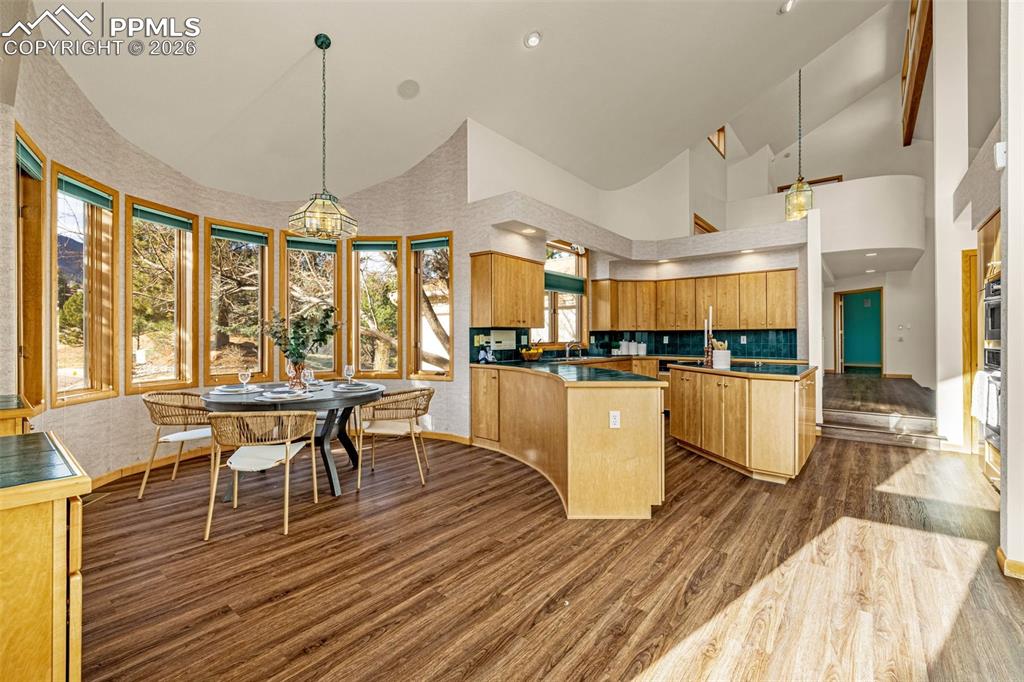 Image 13 of 47: Kitchen featuring lofted ceiling, dark wood-type flooring, a peninsula, woo
