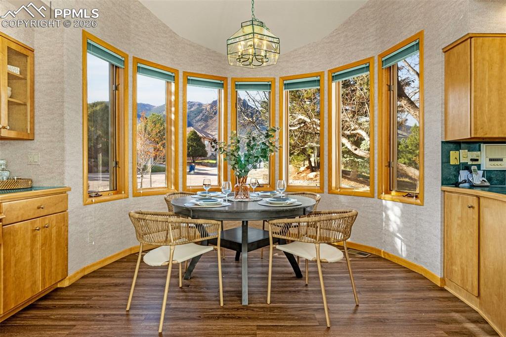 Image 14 of 47: Dining room featuring a mountain view, wallpapered walls, dark wood finishe