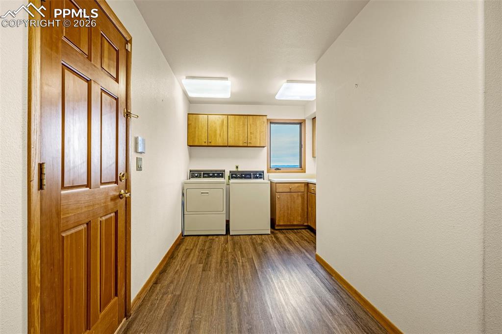 Image 21 of 47: Laundry area featuring cabinet space, dark wood finished floors, and washin