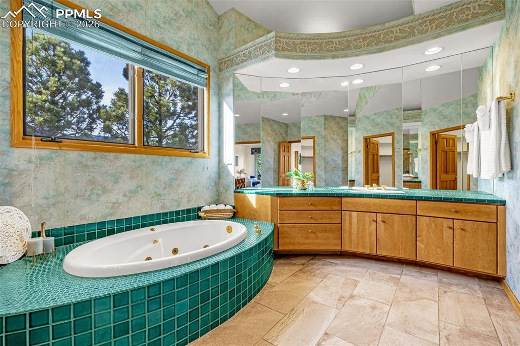 Image 31 of 47: Bathroom featuring a whirlpool tub, vanity, recessed lighting, and wallpape