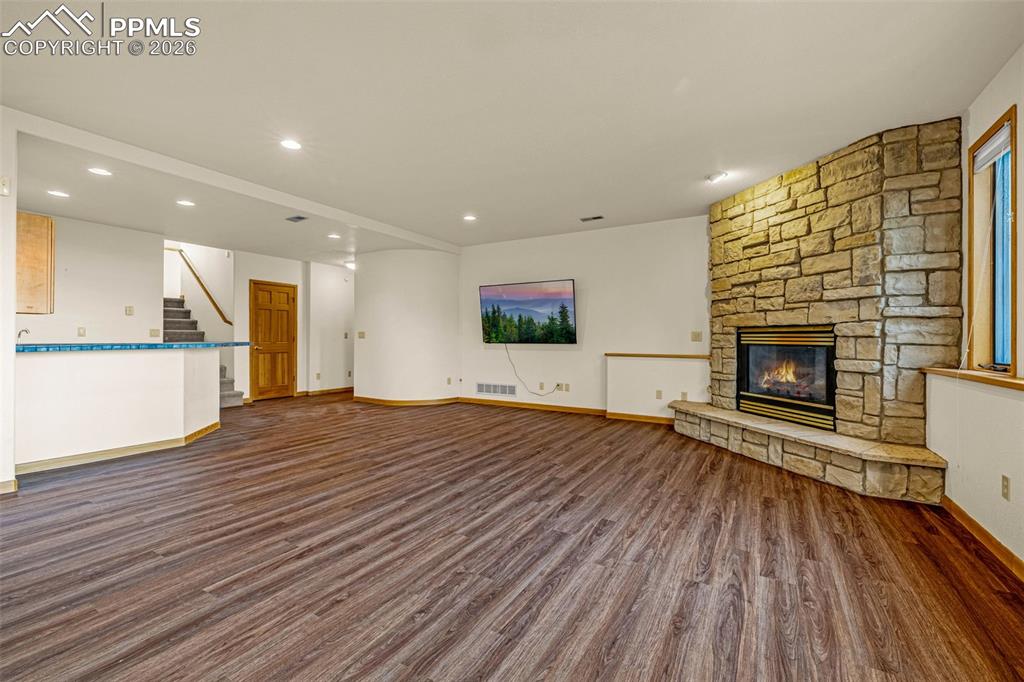 Image 34 of 47: Unfurnished living room featuring dark wood finished floors, a fireplace, a