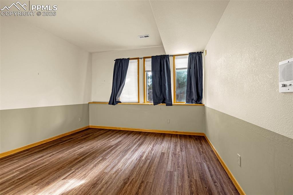 Image 36 of 47: Spare room featuring dark wood-style flooring and a textured wall
