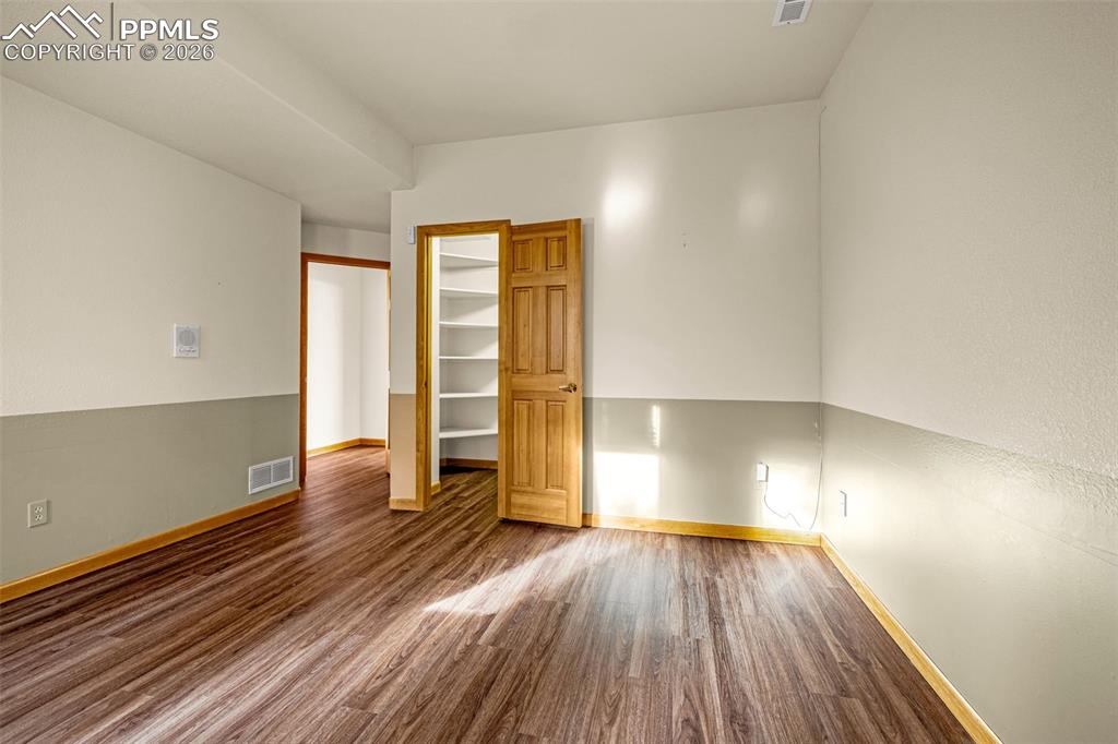 Image 37 of 47: Unfurnished room featuring dark wood-style floors and baseboards