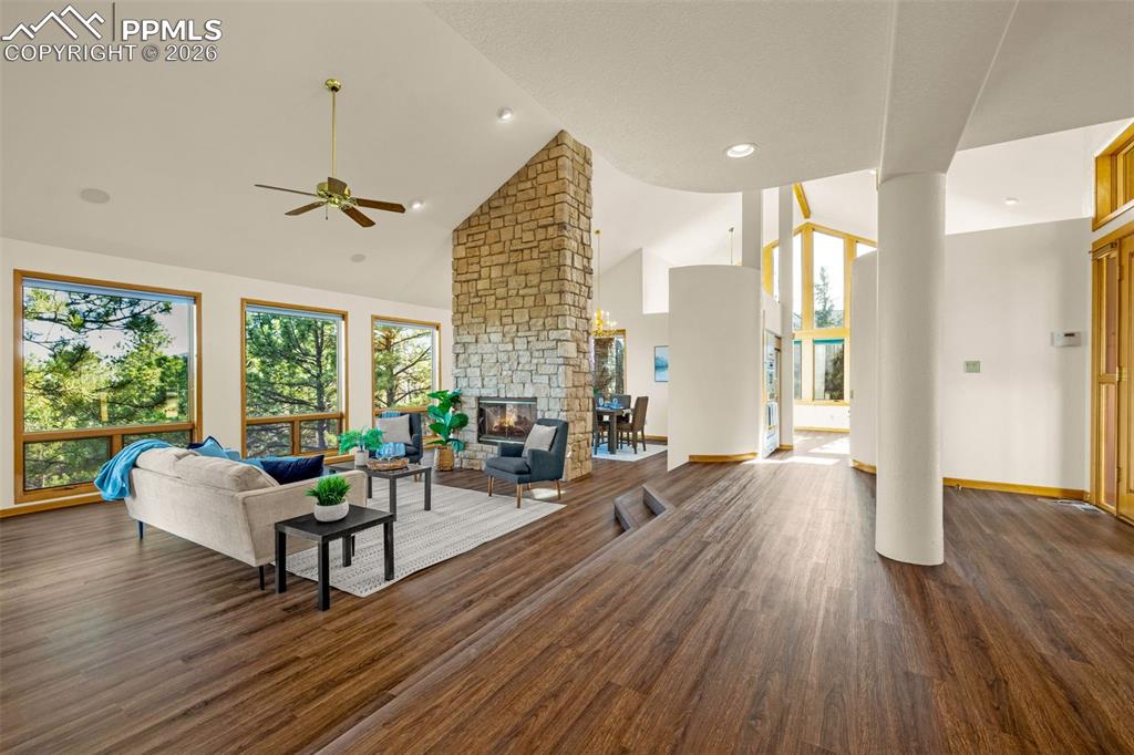 Image 5 of 47: Living area with dark wood-style flooring, lofted ceiling, a fireplace, and