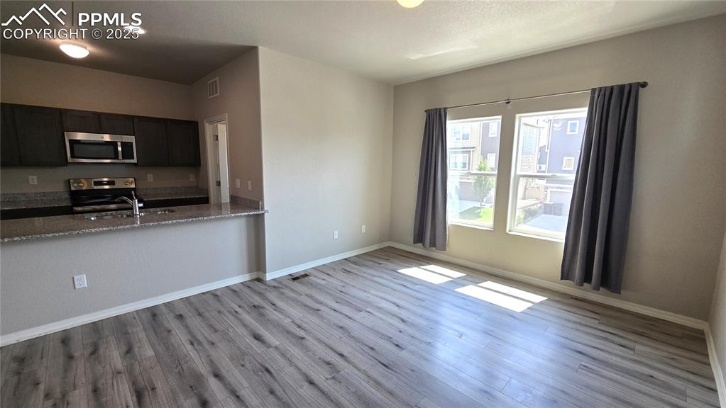 Image 12 of 29: Unfurnished living room with wood-style  floors.